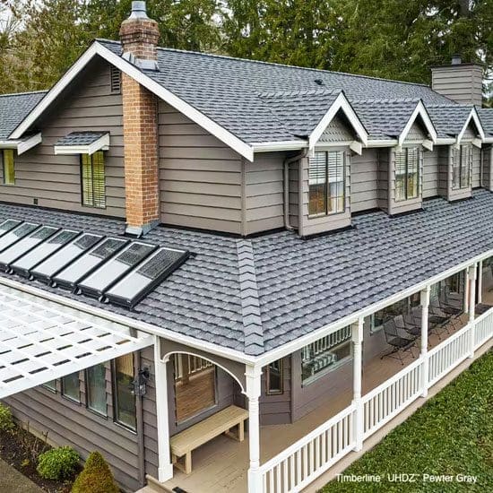 Beige home with a gray roof featuring new GAF Timberline UHDZ shingles